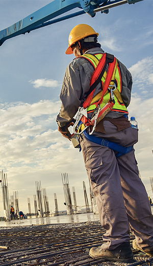 Site supervisor in safety harness overlooking a rebar deck